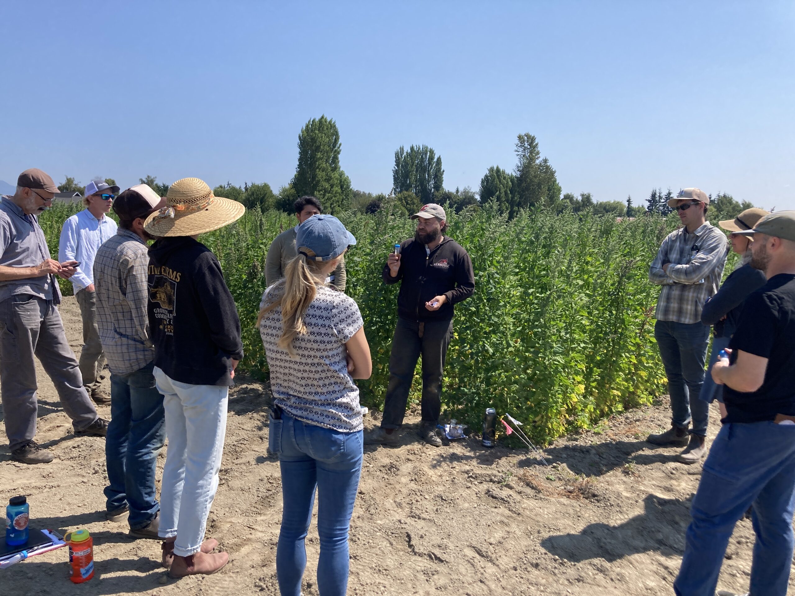 A graduate student giving a talk to a group in front of a quinoa plot.