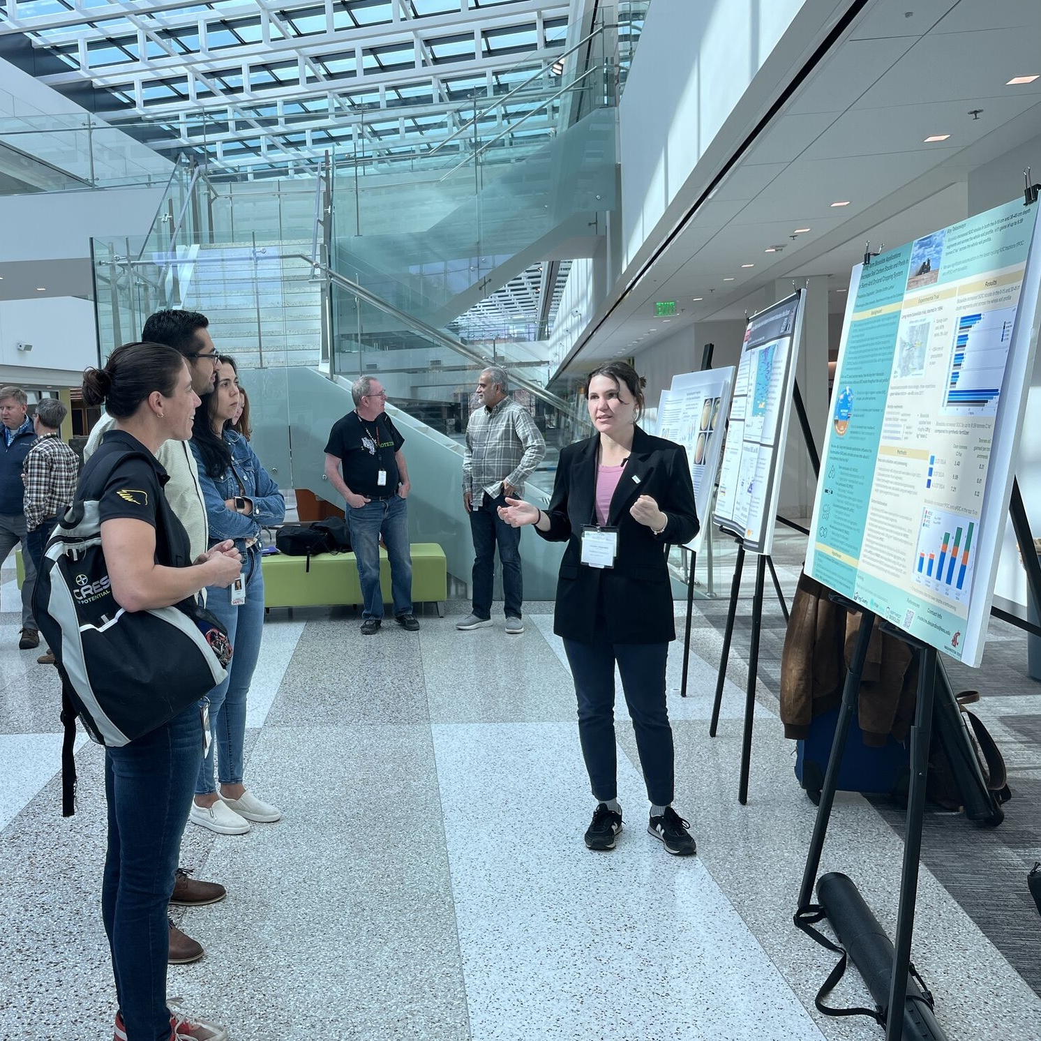 Madeline Desjardins presenting a poster to attendees.