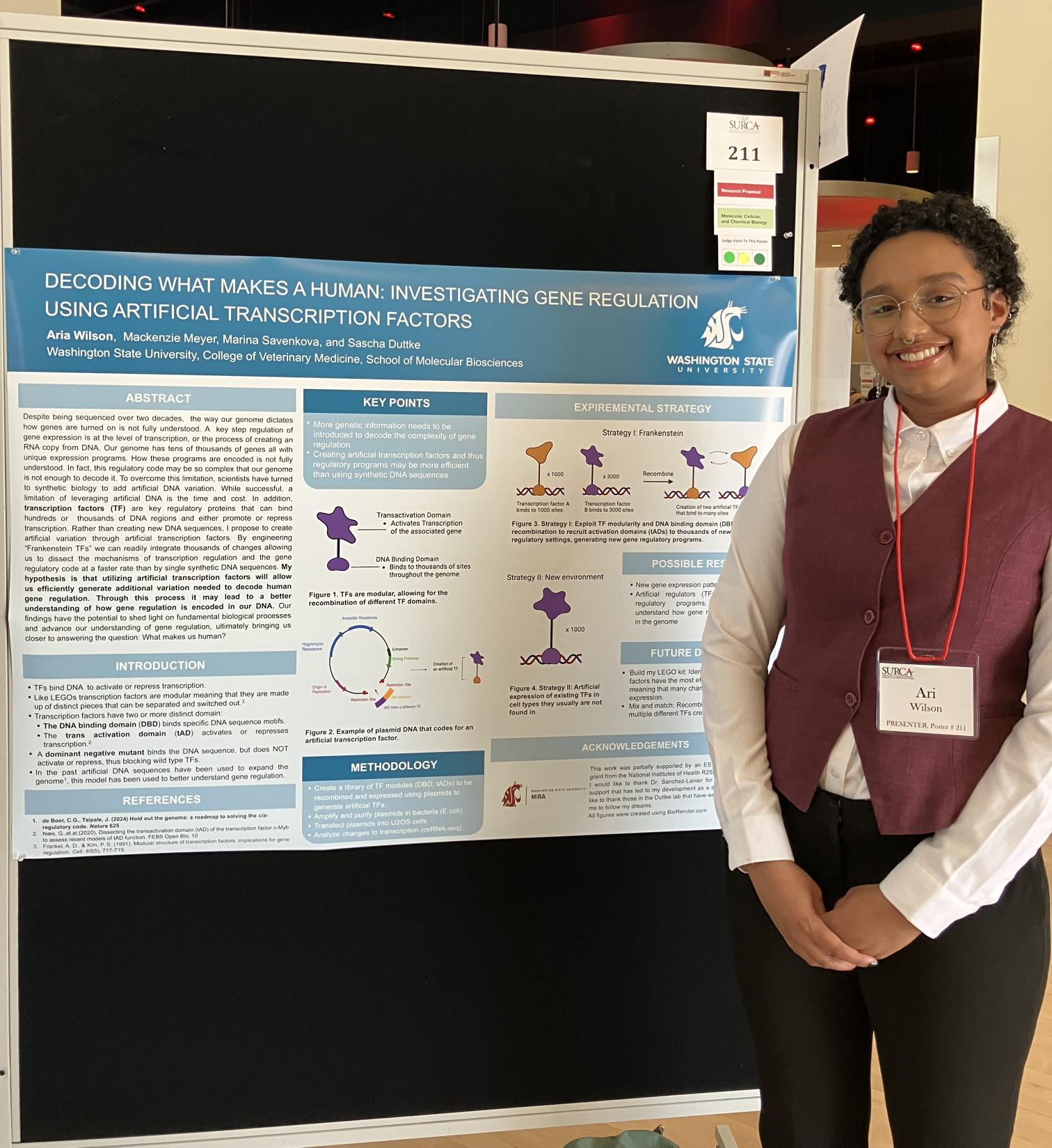Ari Wilson (a young woman) standing in front of her scientific poster (described above) smiling with her hands clasped.