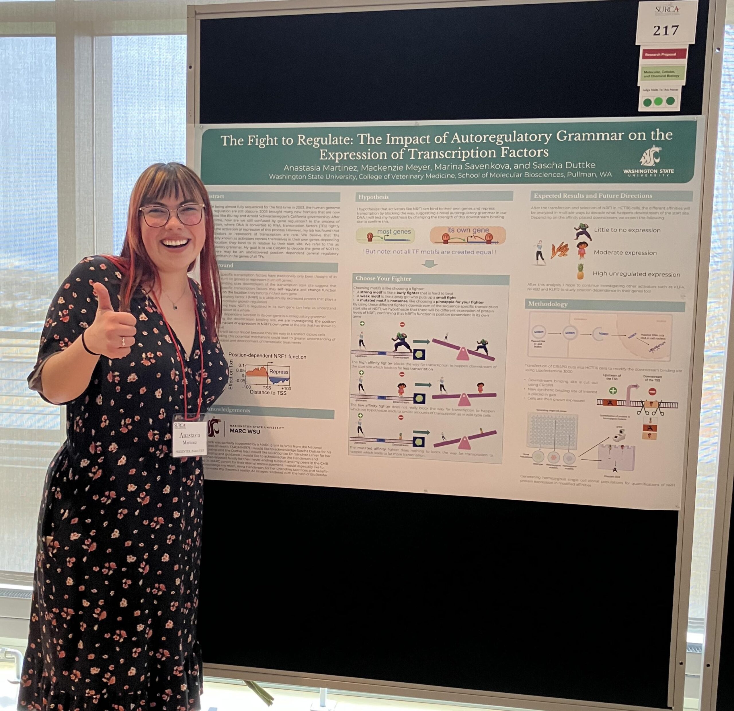 Anastasia Martinez (a young woman) stands next to her scientific poster (described above) smiling and giving a thumbs up to the audience.