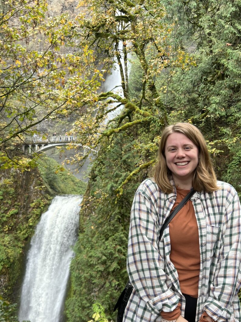 Picture of Mackenzie Meyer smiling next to a waterfall