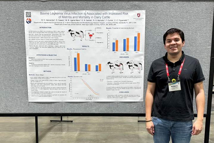 Modesto standing next to his research poster.