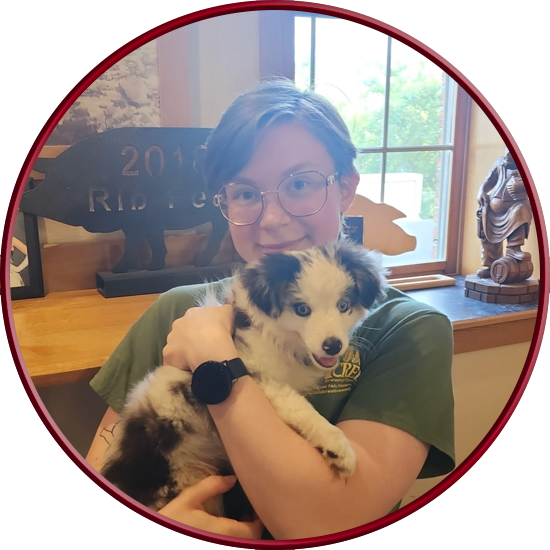 Picture of Arthur smiling and holding a cute dog that belongs to a random person.