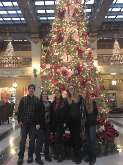 4 lab members at SPOKANE’S HISTORIC DAVENPORT standing in front of Christmas Tree