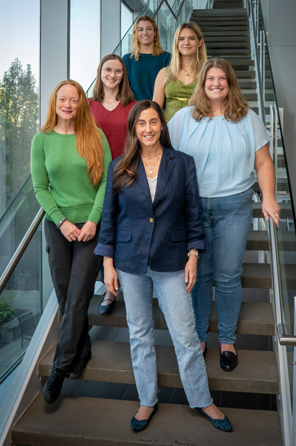 Six members of the lab team standing on the stairs smiling. 