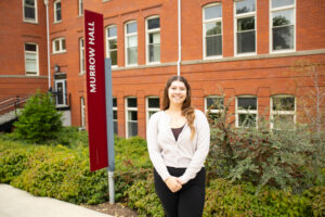 Photo of Anika standing in front of Murrow Hall. 