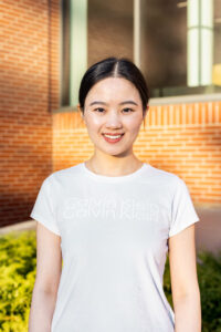 Photo of Li Yuan standing in front of brick building.