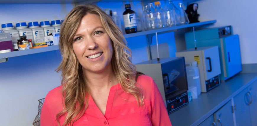 Dr. Shane Hentges in her lab, radiating energy and wearing a warm, welcoming smile.