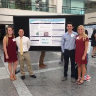 undergraduate students presenting a symposium poster based on research in the Dowd lab