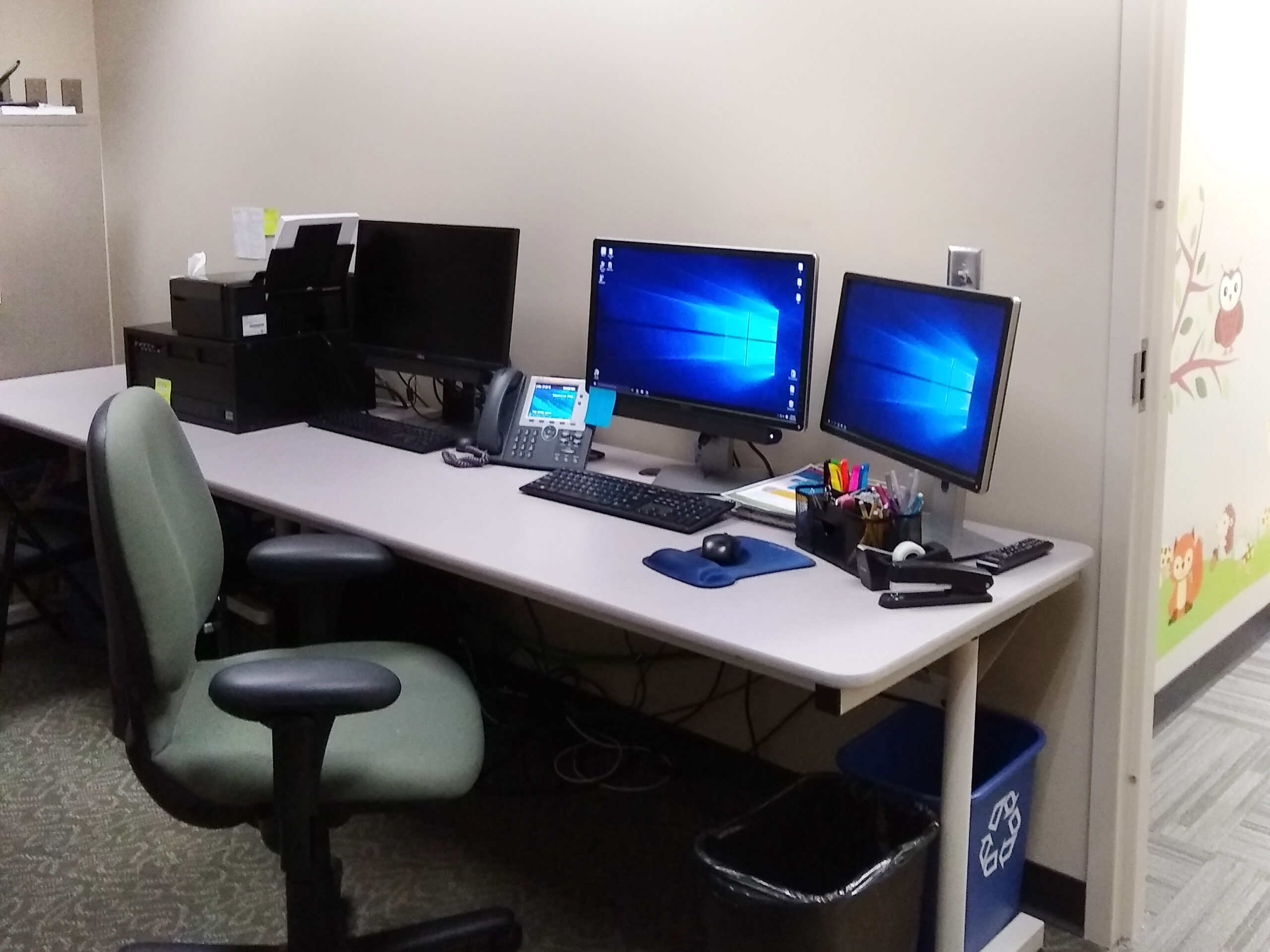 Research room with a desk, chair and computer with multiple monitors.