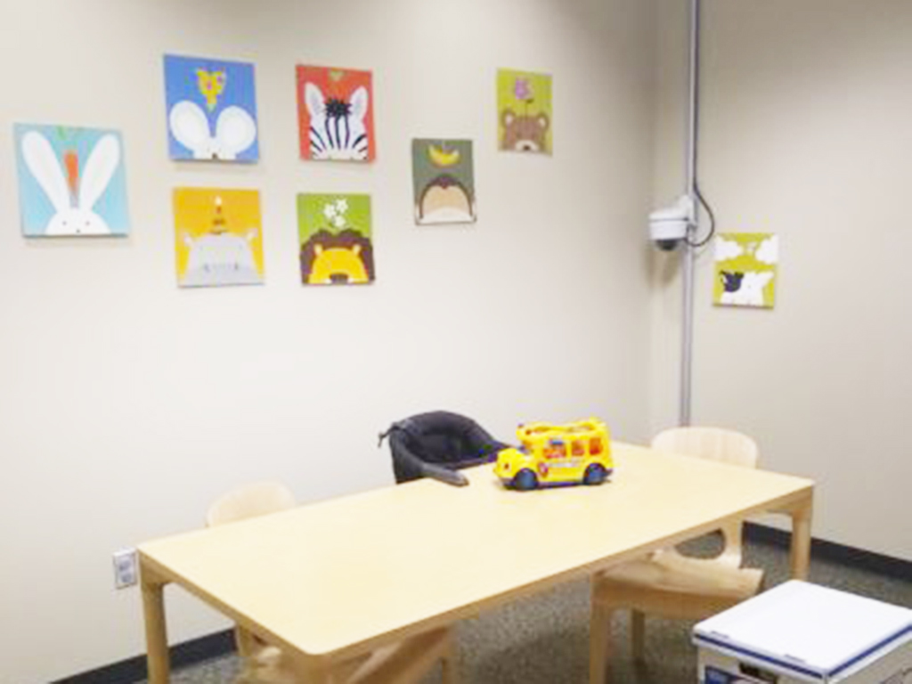 Assessment Room with a large table, two chairs and a toy bus on the table.