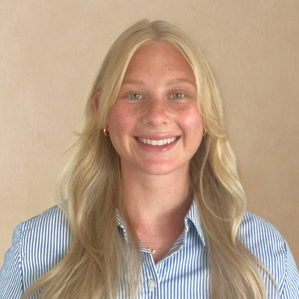 Marissa Andrews in a blue striped shirt in front of yellow background