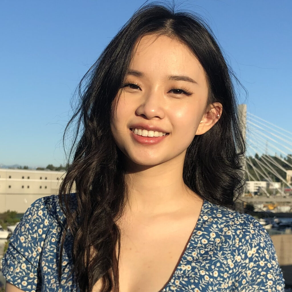 Lisa Ngo in a blue dress smiling with a blue sky background