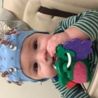 Baby boy with blue research cap on and colorful toy keys