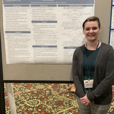 Female student standing next to a presentation board