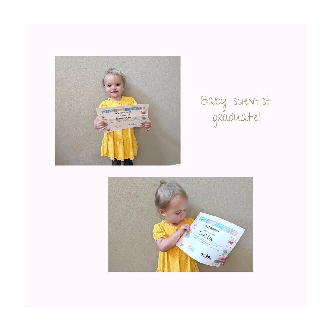 Toddler girl in yellow dress holding certificate