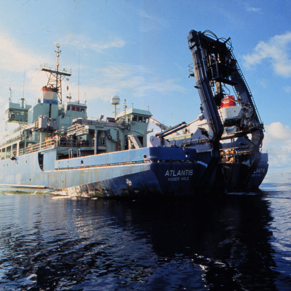 Alvin's mother ship, the Atlantis, prepares to lower Alvin to the water from the A-frame boom. Photo Woods Hole Oceanographic Institute.
