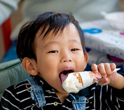 Two-year-old Daniel Koh savors a vanilla ice cream cone at Ferdinand's 60th anniversary celebration.