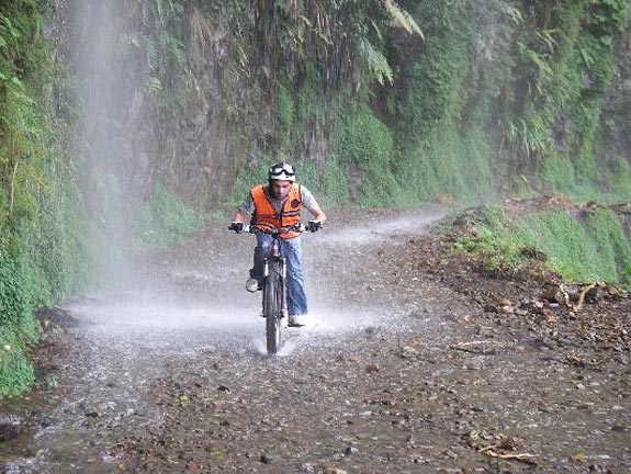 Water pours off the mountain onto bicyclists