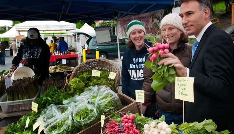 Farmer Erickson-Brown, center, and an intern visit with King County Executive Dow Constantine