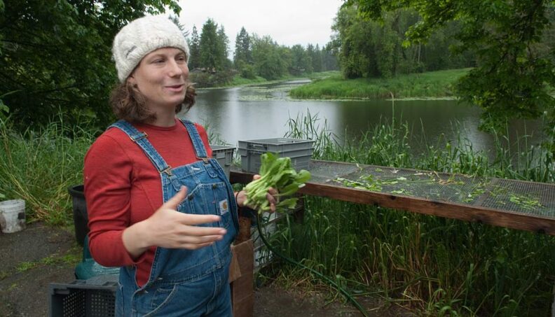 Siri Erickson-Brown washes greens by an oxbow of the Snoqualmie River
