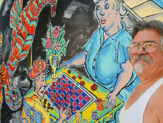 Patrick Siler next to mural in Pullman