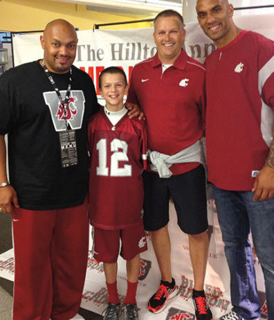Derek Sparks ’95 (left) and Mkristo Bruce ’06 (right) pose with Coug fans on a September weekend when dozens of football players came back to campus. Courtesy Derek Sparks