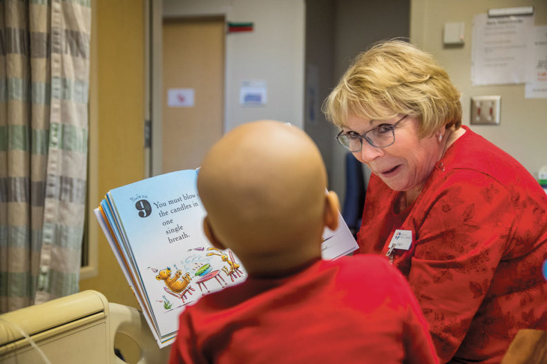 Spokane librarian Cindy Wigen reads to a young patient at Sacred Heart Hospital