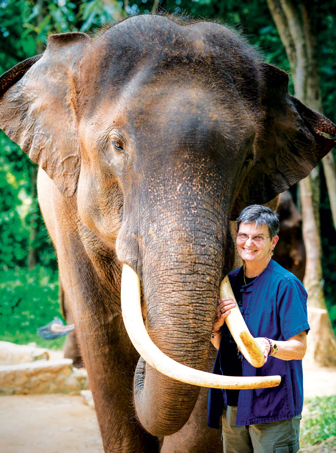 Janine Brown stands by an elephant at the National Zoo