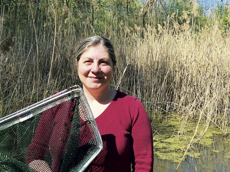 Erica Crespi with a net by a pond