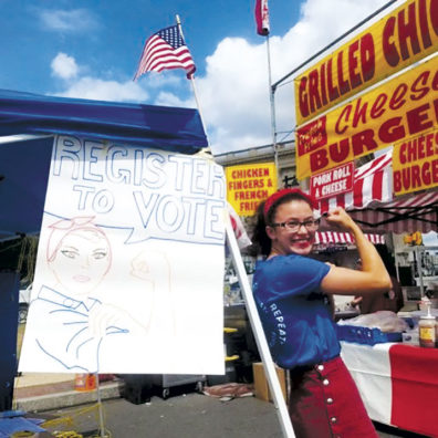 Andaya Sugayan registers voters, with her handmade sign
