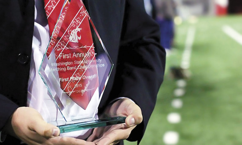 Man holds trophy for WSU Cougar Marching Band
