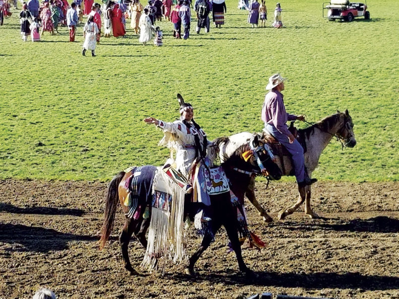 Participants ride horses in the Round-Up Native American Parade