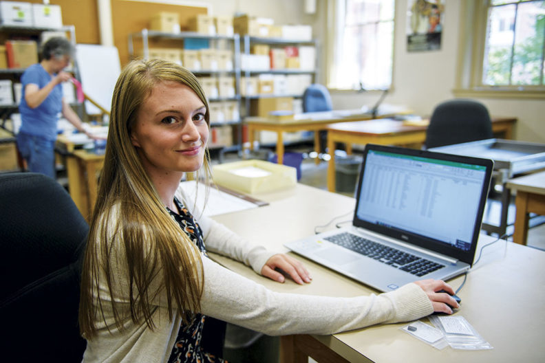 Cassady Fairlane seated by a computer in the WSU Museum of Anthropology