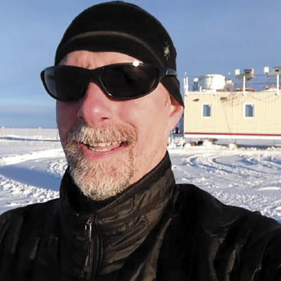 Von Walden wearing sunglasses in front of his mobile laboratory in Greenland