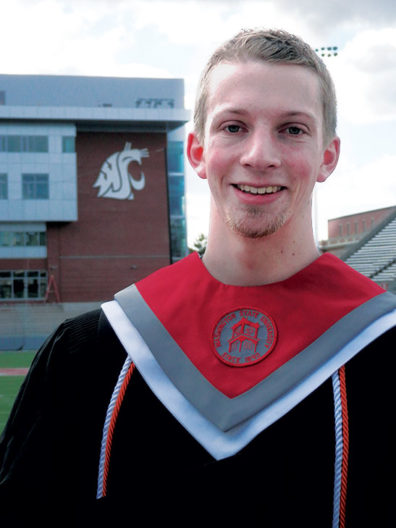 Jonathon Waldrip with WSU graduation robes at Pullman campus