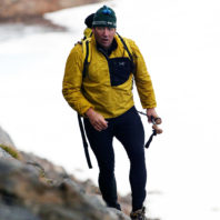 Buddy Levy trekking steep scree slopes above a glacier in Southeastern Greenland.