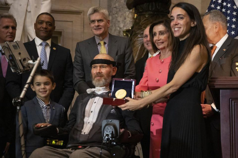 Steve Gleason receives the Congressional Gold Medal surrounded by his family, House Speaker Nancy Pelosi, and other members of Congress