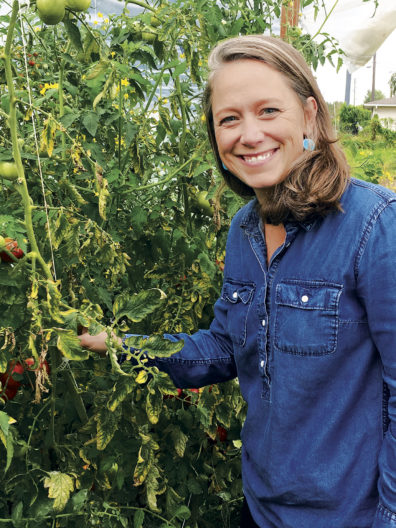 Jordan Jobe shows a tomato plant at a farm