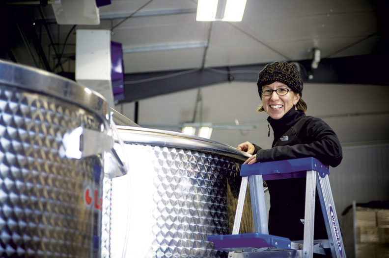 Coco Umiker examines a wine making tank