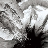 Hand dropping volcanic ash into a bag