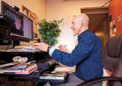 William Kabasenche sits at a computer for a Zoom meeting