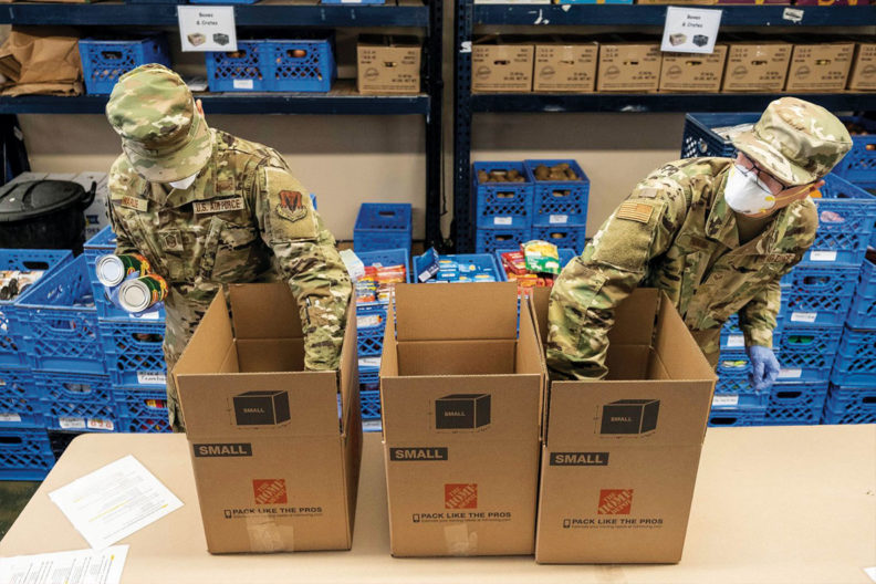 Two Air National Guard members get canned goods from box for food bank