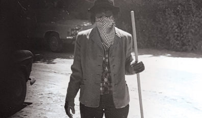 Danielle Dorrian in 1980 wearing a face cloth, holding a broom to sweep ash from Mount St. Helens
