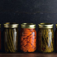 Various Types of Canned Vegetables on a Wooden Table in a Dark Environment