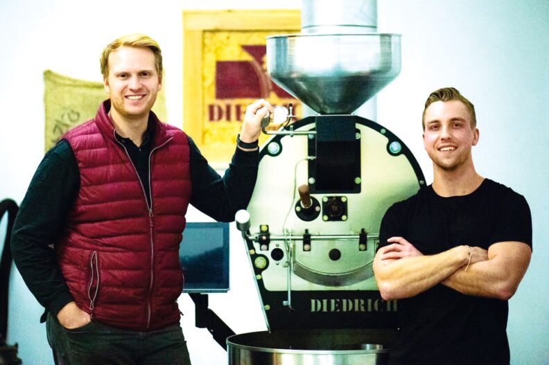 Kyle O’Malley and Grant Schoenlein next to grinder at Kamiak Coffee