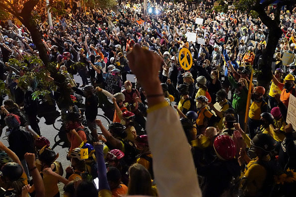 Thousands of marchers during the 2020 Black Lives Matter protests in Portland, Oregon. A raised fist in the foreground