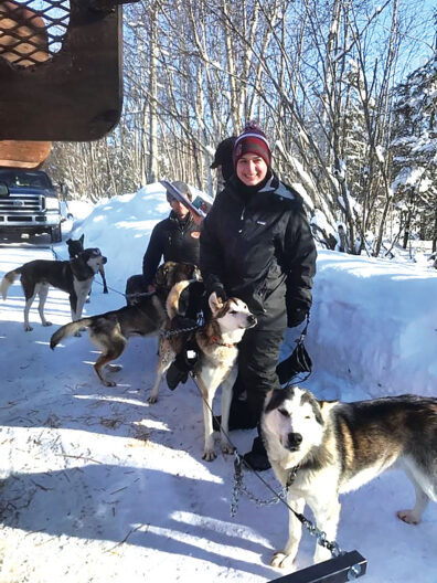 Laura White with sled dogs at the 2020 Iditarod Race