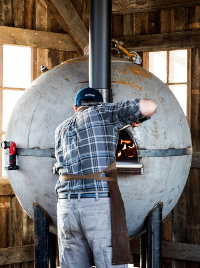 Removing bread from buoy oven at WSU Bread Lab