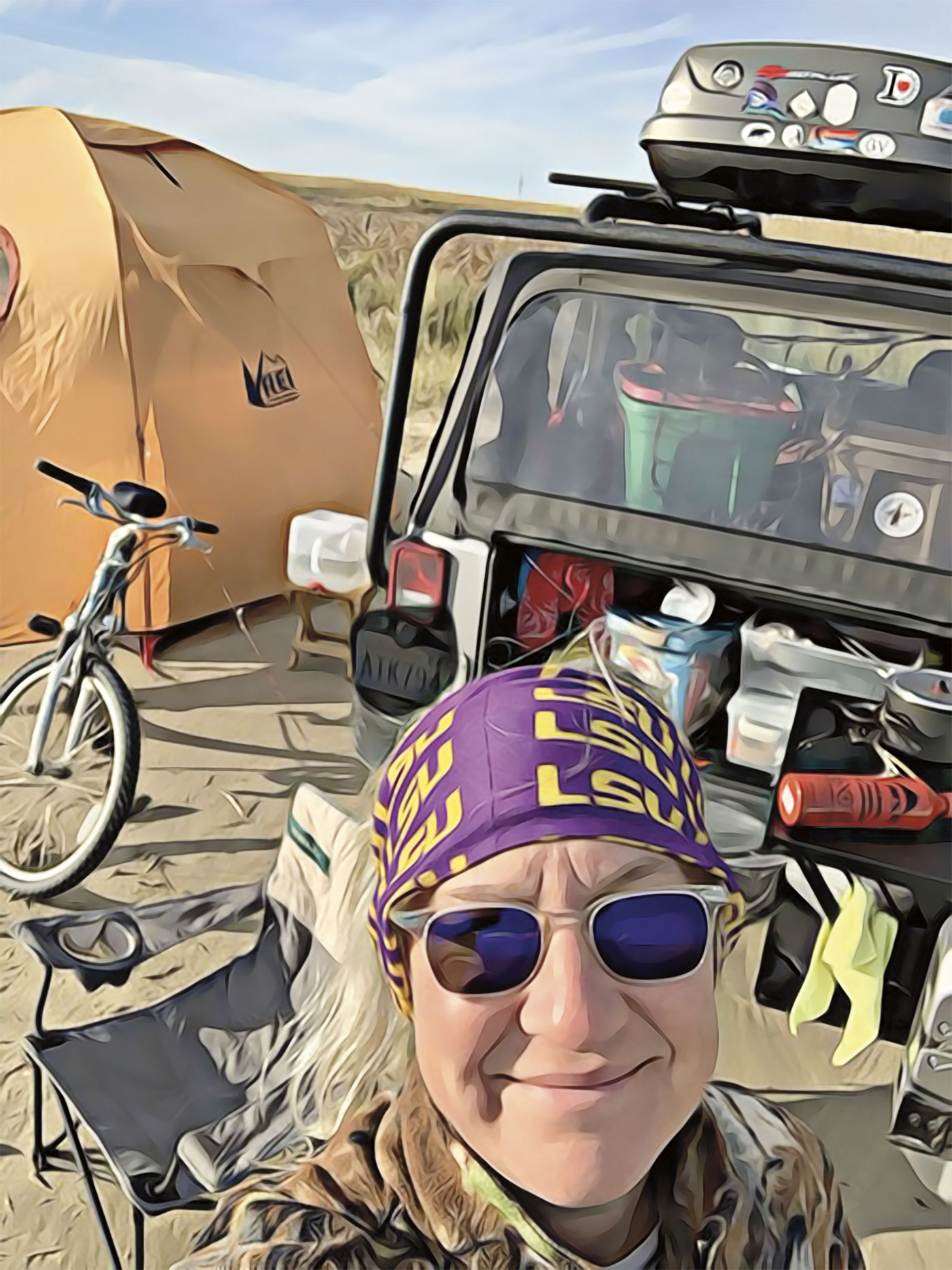 Michelle in front of her jeep, bike, and tent